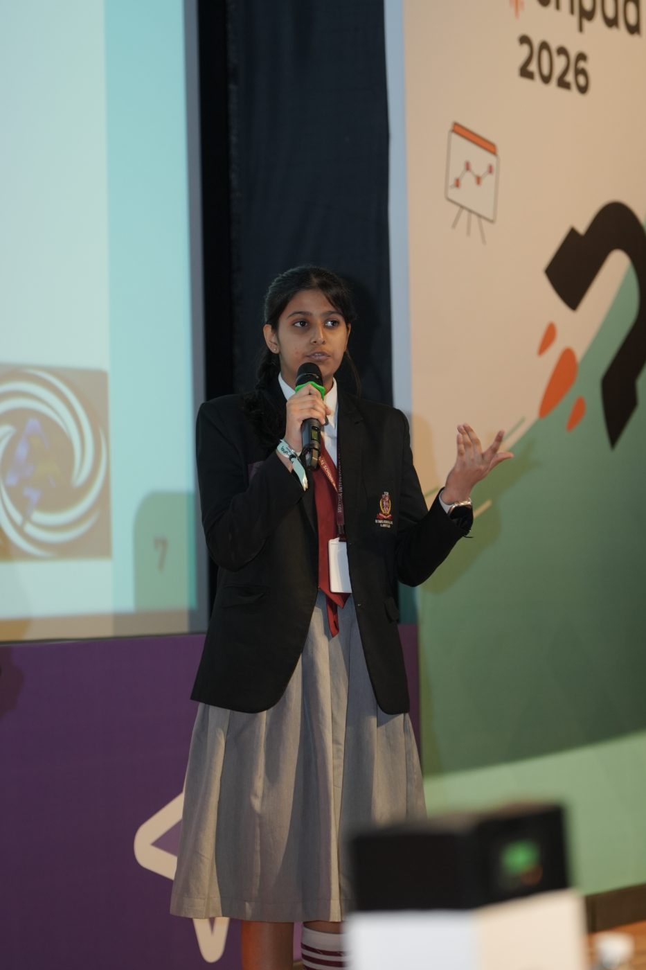 A student holding a microphone as she presents her team's idea